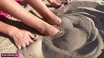Afspelen Het meisje op het strand laat haar mooie benen zien