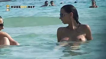 Jouer Une chaude nudiste prend un bain de soleil sur la plage nudiste